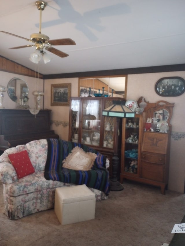 carpeted living room with ceiling fan and wooden walls