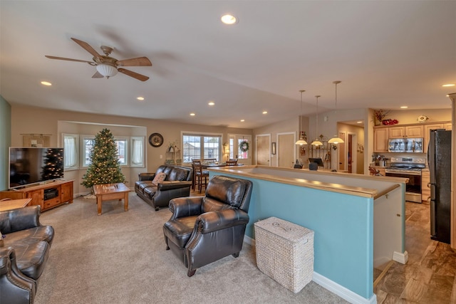 living room featuring ceiling fan, light colored carpet, and lofted ceiling