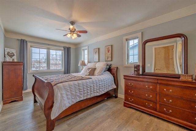 bedroom with multiple windows, ceiling fan, and light wood-type flooring