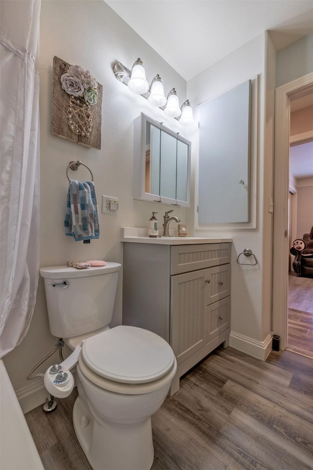 bathroom with hardwood / wood-style flooring, vanity, and toilet