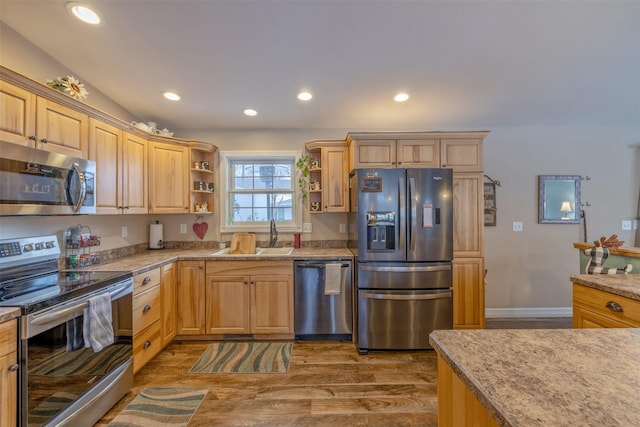 kitchen with hardwood / wood-style floors, appliances with stainless steel finishes, light brown cabinetry, and sink