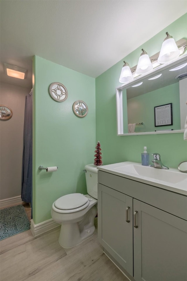 bathroom with vanity, hardwood / wood-style flooring, toilet, and walk in shower