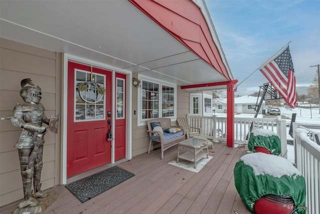 snow covered property entrance with a porch