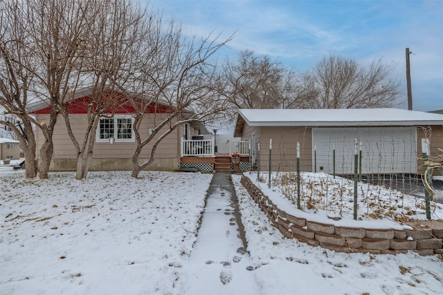 yard layered in snow featuring a garage and a deck