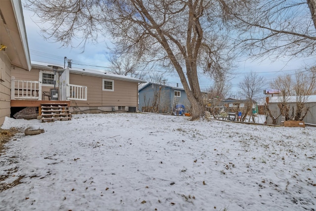 yard layered in snow with a wooden deck