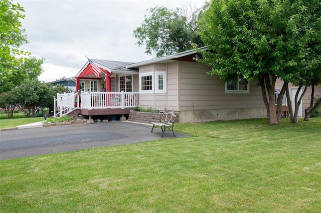 view of front facade with a deck and a front lawn