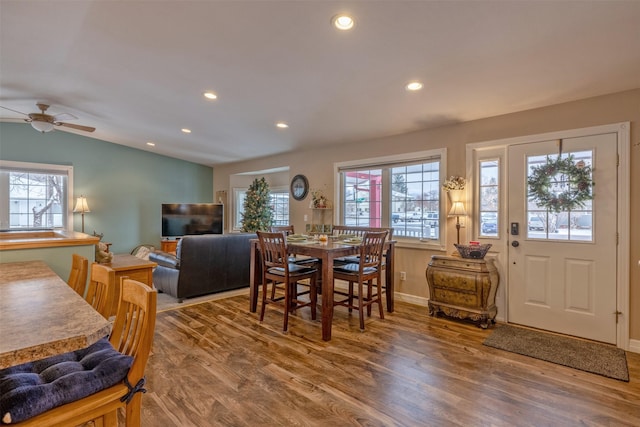 dining space featuring wood-type flooring, vaulted ceiling, and ceiling fan