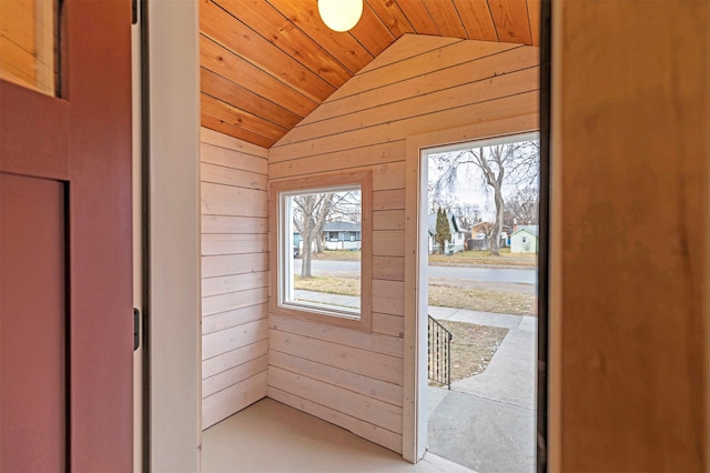 entryway with wooden walls, vaulted ceiling, and wooden ceiling