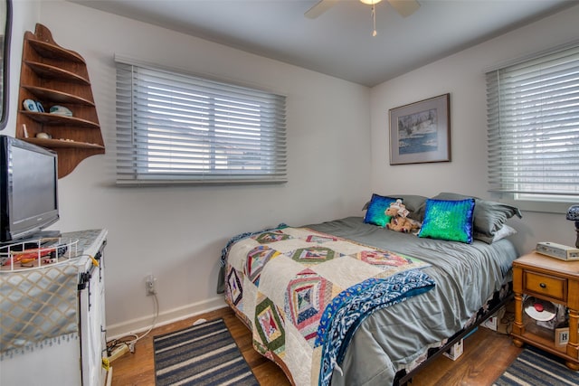 bedroom with multiple windows, ceiling fan, and dark wood-type flooring