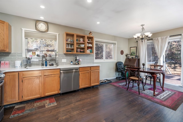 kitchen with dishwasher, sink, dark wood-type flooring, a chandelier, and decorative light fixtures