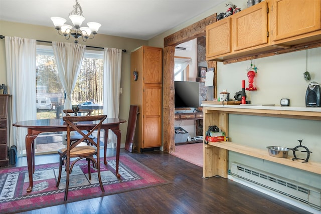 dining room featuring an inviting chandelier, baseboard heating, a wall unit AC, and dark wood-type flooring