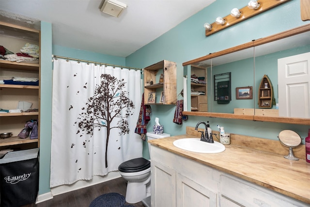 bathroom with hardwood / wood-style flooring, vanity, curtained shower, and toilet