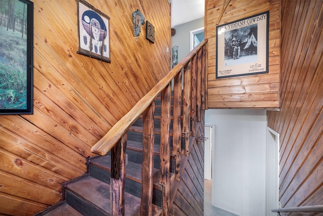 stairway featuring wood walls and vaulted ceiling