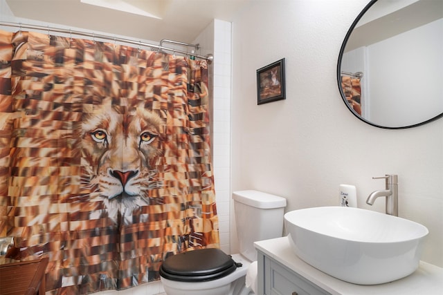 bathroom featuring curtained shower, vanity, and toilet