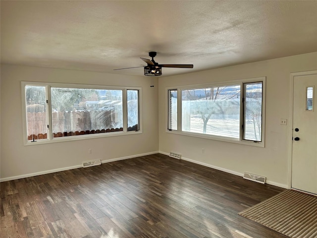 entrance foyer featuring a textured ceiling, ceiling fan, a healthy amount of sunlight, and dark hardwood / wood-style floors