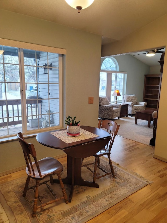 dining room with wood-type flooring and lofted ceiling