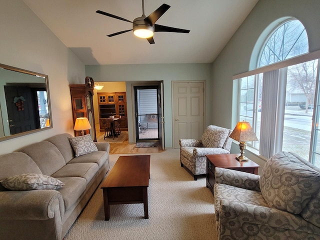 living room featuring ceiling fan, light colored carpet, and lofted ceiling