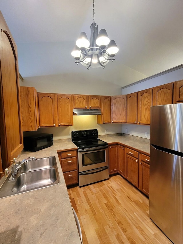 kitchen featuring sink, lofted ceiling, stainless steel appliances, and hanging light fixtures