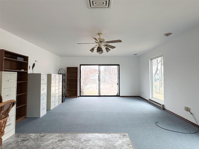 unfurnished living room with carpet, baseboard heating, a healthy amount of sunlight, and ceiling fan