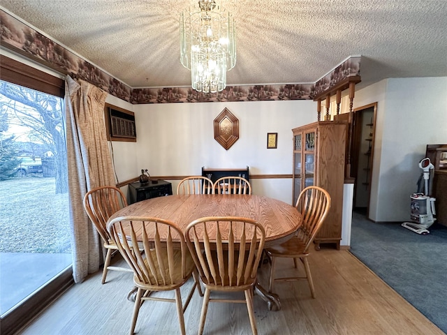 carpeted dining area featuring a wall mounted air conditioner, a textured ceiling, and an inviting chandelier