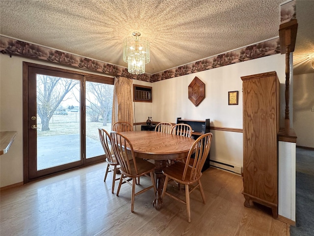 dining space featuring a textured ceiling, wood-type flooring, and a baseboard radiator