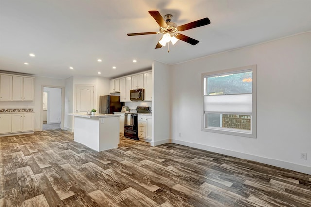 kitchen featuring white cabinetry, ceiling fan, a center island with sink, black appliances, and hardwood / wood-style flooring