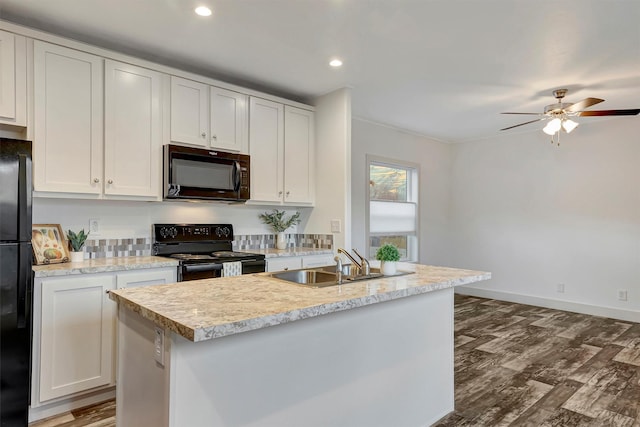 kitchen featuring black appliances, white cabinets, a center island with sink, sink, and dark hardwood / wood-style floors