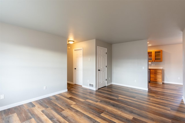 unfurnished room featuring dark wood-type flooring