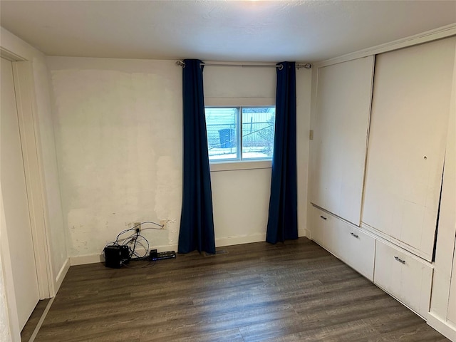 unfurnished bedroom featuring dark hardwood / wood-style floors and a closet