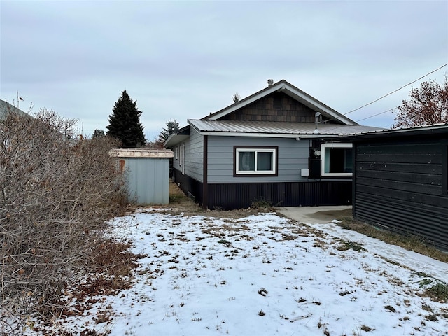 snow covered property featuring a shed