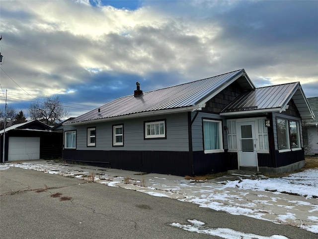 view of front facade featuring a garage and an outbuilding