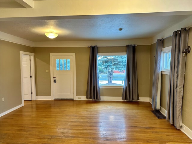 foyer featuring a textured ceiling and light hardwood / wood-style floors