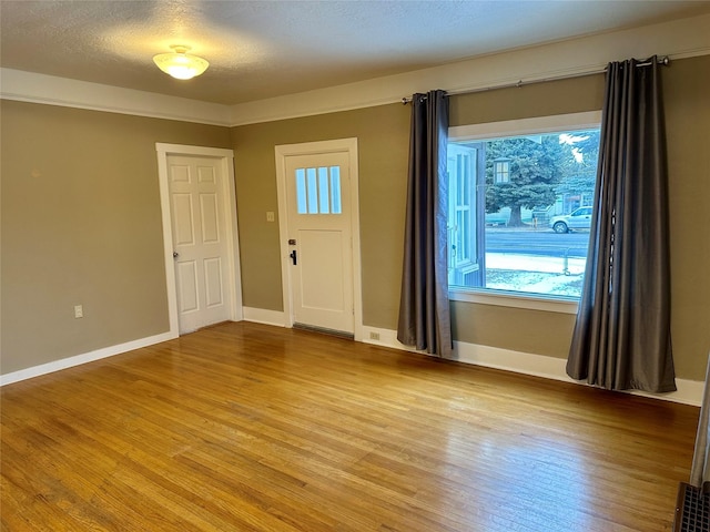 foyer entrance featuring light hardwood / wood-style flooring and a textured ceiling