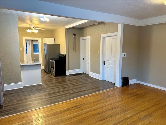 unfurnished living room featuring a textured ceiling, dark hardwood / wood-style floors, and ceiling fan