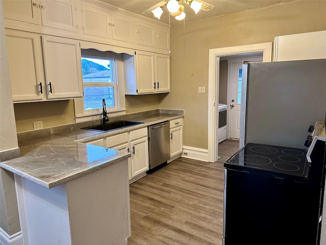 kitchen featuring refrigerator, sink, electric range, stainless steel dishwasher, and white cabinetry