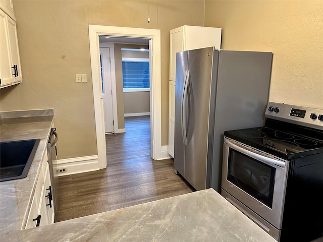 kitchen with white cabinets, sink, stainless steel range with electric cooktop, and dark hardwood / wood-style floors