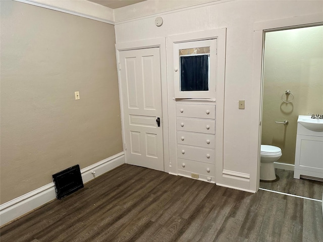 bedroom featuring ensuite bathroom, dark wood-type flooring, and sink