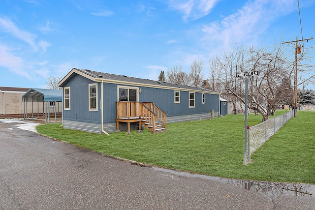 manufactured / mobile home with a front lawn and a carport