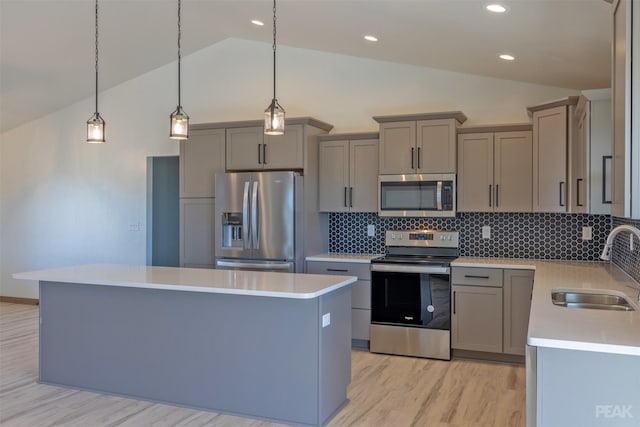 kitchen featuring sink, tasteful backsplash, pendant lighting, vaulted ceiling, and appliances with stainless steel finishes