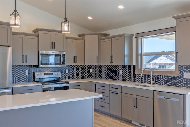 kitchen with appliances with stainless steel finishes, tasteful backsplash, sink, hanging light fixtures, and lofted ceiling