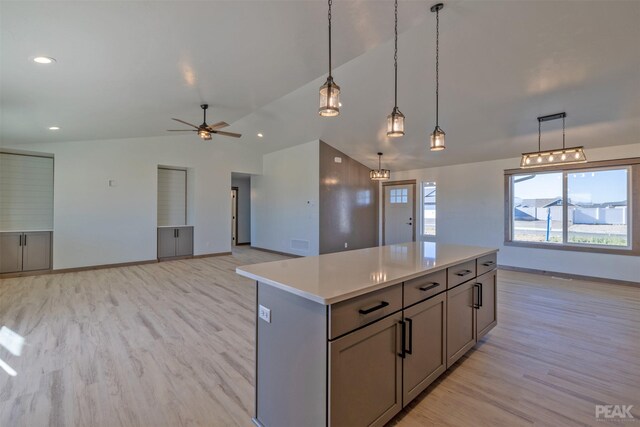 kitchen featuring stainless steel fridge, lofted ceiling, hanging light fixtures, and light hardwood / wood-style flooring