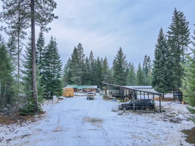 yard covered in snow featuring a carport