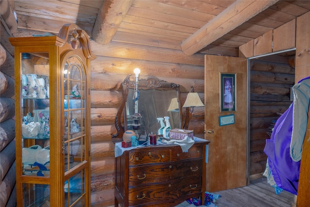 bedroom featuring beam ceiling, rustic walls, wooden ceiling, and wood-type flooring