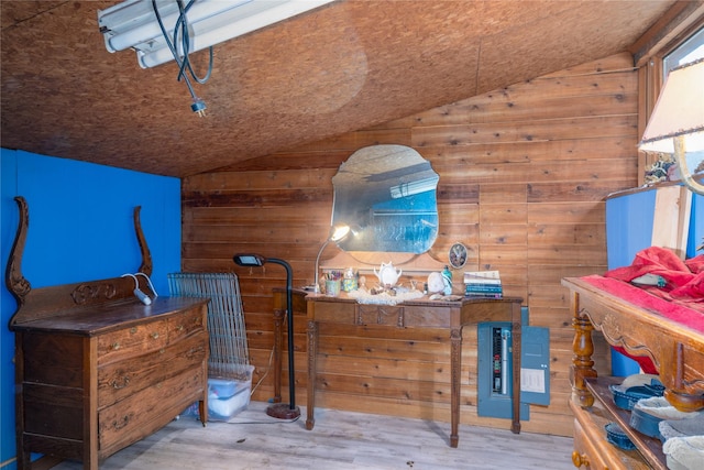 bedroom with wood walls, wood-type flooring, and lofted ceiling