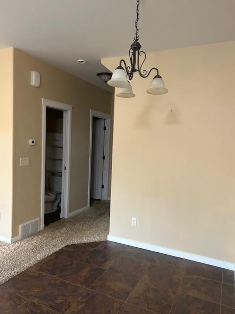 unfurnished room featuring a chandelier