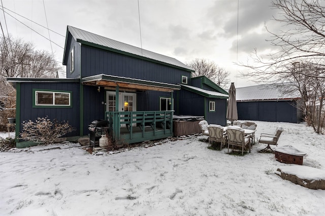 snow covered property with a hot tub