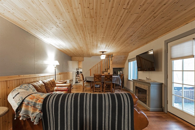 living room with hardwood / wood-style floors, wood walls, wood ceiling, and ornamental molding