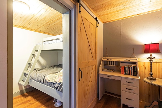 bedroom with lofted ceiling, crown molding, hardwood / wood-style flooring, a barn door, and wood ceiling