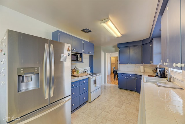 kitchen with white range with electric stovetop, stainless steel fridge with ice dispenser, blue cabinets, light countertops, and a sink