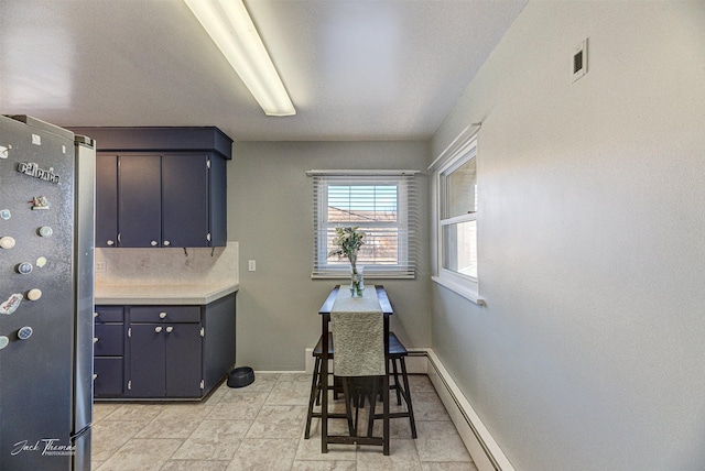 interior space with visible vents, baseboards, light countertops, and freestanding refrigerator